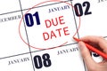 Hand writing text DUE DATE on calendar date January 1 and circling it. Payment due date Royalty Free Stock Photo