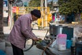 21st february 2021. Dehradun, Uttarakhand, India. A roadside poor tea and snack stall vendor cutting vegetables for cooking in