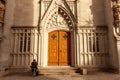 Unidentified man sit near main emtrance to St. Laurenzen Church in St. Gallen, Switzerland