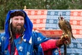 Peregrine Falcon sits on trainer`s hand at `Birds of Prey` exhibition at St Ives Medieval Faire