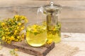 St. John's wort tea is a therapeutic healthy drink A teapot and a cup on a wooden background A bouquet of St Royalty Free Stock Photo