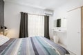 St Julians, Malta - April 28th 2020: Light, bright double bedroom with purple bedding and grey and white walls