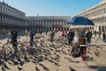Tourists feed pigeons at Piazza San Marco in Venice, Italy. Royalty Free Stock Photo
