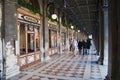People walk by the passage in front of the windows of the famous Florian cafe at Piazza San Marco in Venice, Italy.