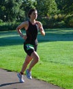 Female Triathlete running in Black Skinsuit.