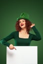 St Patrick Day. Young oktoberfest woman, wearing a dress and green hat with white banner for copy space Royalty Free Stock Photo