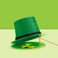 St Patrick minimal treasure concept. Striking green glittery top hat and golden coins under. Vivid green creative background