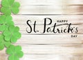 Happy St. Patrick`s Day Black Text Typography Wooden Background with Green Shamrocks clover leaf Royalty Free Stock Photo