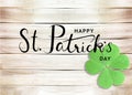 Happy St. Patrick`s Day Black Text Typography Background with Green Shamrocks on Wooden Texture Royalty Free Stock Photo