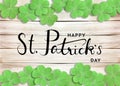 Happy St. Patrick`s Day Black Text Typography Background with Green Shamrocks on Wooden Texture Royalty Free Stock Photo