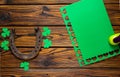 St. Patrick`s Day banner with an old rusty horseshoe, green cutout shamrocks and piece of green paper with a craft punch