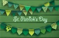 St. patrick`s day card. Colorful paper garlands on green wooden background.