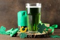 St.Patrick `s Day. celebration. green beer, leprechaun hat, coins, bow tie and clover on a brown background