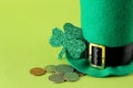 St.Patrick `s Day. celebration. The hat of a leprechaun, coins and a leaf of clover is a blueprint on a bright green background.