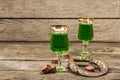 St. Patrick`s Day concept. Traditional green cocktail, sweet chocolate in the shape of clover leaves