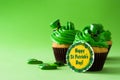 St. Patrick`s Day cupcake on green background.