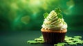 St. Patrick's Day cupcake with whipped cream decorated clover on green background.