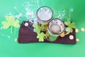 St. Patrick\'s Day, fresh beer in glass mugs and a bottle, gold coins, on a red wooden table Royalty Free Stock Photo