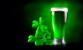 St. Patrick`s Day Green Beer pint over dark green background, decorated with shamrock leaves. Glass of Green beer close-up Royalty Free Stock Photo