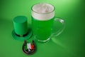 St Patrick`s Day green beer with shamrock, horseshoe and Leprechaun hat against green background. Royalty Free Stock Photo