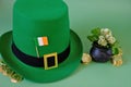 St.Patrick 's Day. leprechaun hat, flag of Ireland, bowler hat with coins, bunch of clovers on a green background. Saint
