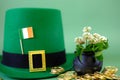 St.Patrick 's Day. leprechaun hat, flag of Ireland, bowler hat with gold coins, bunch of clovers on a green background