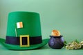 St.Patrick 's Day.Green leprechaun hat, flag of Ireland, bowler hat with coins, bunch of clovers on a green background