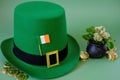 St.Patrick 's Day.Green leprechaun hat, flag of Ireland, bowler hat with coins, bunch of clovers on a green background