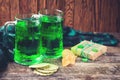 St. Patrick`s Day greeting card with green beer and gift. Rustic style. Glass of beer on wooden table Royalty Free Stock Photo