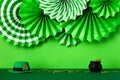 Folding paper fans, leprechauns hat, pot of gold coins on green table