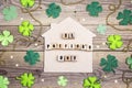 St.Patrick`s day home symbol with clover leafs on wooden backgro Royalty Free Stock Photo