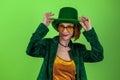 St. Patrick`s Day leprechaun model woman. Beautiful smiling woman wearing green hat. Green background Royalty Free Stock Photo