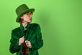 St. Patrick`s Day leprechaun model woman. Beautiful smiling woman wearing green hat. Green background Royalty Free Stock Photo