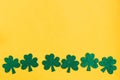 St. Patrick`s Day low border paper shamrocks on yellow background. Royalty Free Stock Photo