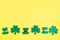 St. Patrick`s Day lower border paper shamrocks on bright yellow background. Royalty Free Stock Photo