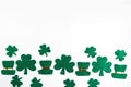 St. Patrick`s Day lower border shamrocks and leprechaun hats on white background. Royalty Free Stock Photo