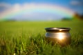 St. Patrick\'s day shiny pot of gold on meadow with rainbow in background Royalty Free Stock Photo