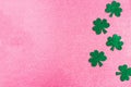 St. Patrick`s Day side border paper shamrocks on pink glitter background. Royalty Free Stock Photo