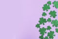 St. Patrick`s Day side border paper shamrocks on purple background. Royalty Free Stock Photo