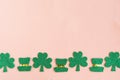 St. Patrick`s Day side border shamrocks and leprechaun hats on pastel pink background. Royalty Free Stock Photo