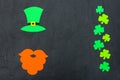 St. Patrick`s Day theme colorful horizontal banner. Green leprechaun hat, beard and shamrock leaves on black background. Felt cra