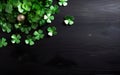 St Patricks Day background with green clover shaped decorations and a golden bead on dark wooden surface. Sale banner template, Royalty Free Stock Photo