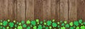 St Patricks Day banner with border border of shamrocks, above view over an old wood background with copy space Royalty Free Stock Photo