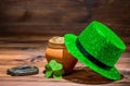 St Patricks day concept with pot full gold coins, horseshoe, green hat and shamrock on vintage wooden background, close up Royalty Free Stock Photo