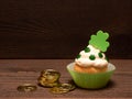 St. Patricks Day Cupcake decorated with Shamrocks and gold coins isolated on Dark Rustic Wood Table and Background with copy space Royalty Free Stock Photo
