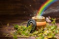 St Patricks day decoration with magic light rainbow pot full gold coins, horseshoe and shamrocks on vintage wooden background, cl Royalty Free Stock Photo