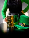 St Patricks day glass beer hand hold costume hat leprechaun black background Royalty Free Stock Photo