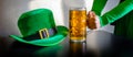 St Patricks day glass beer hand hold costume hat leprechaun black background Royalty Free Stock Photo