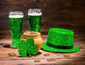 St Patricks day with glasses of green beer, leaf clover, leprechaun hat and pot full gold coins on vintage wooden Royalty Free Stock Photo