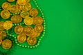St Patricks Day gold chocolate coins and beads Royalty Free Stock Photo